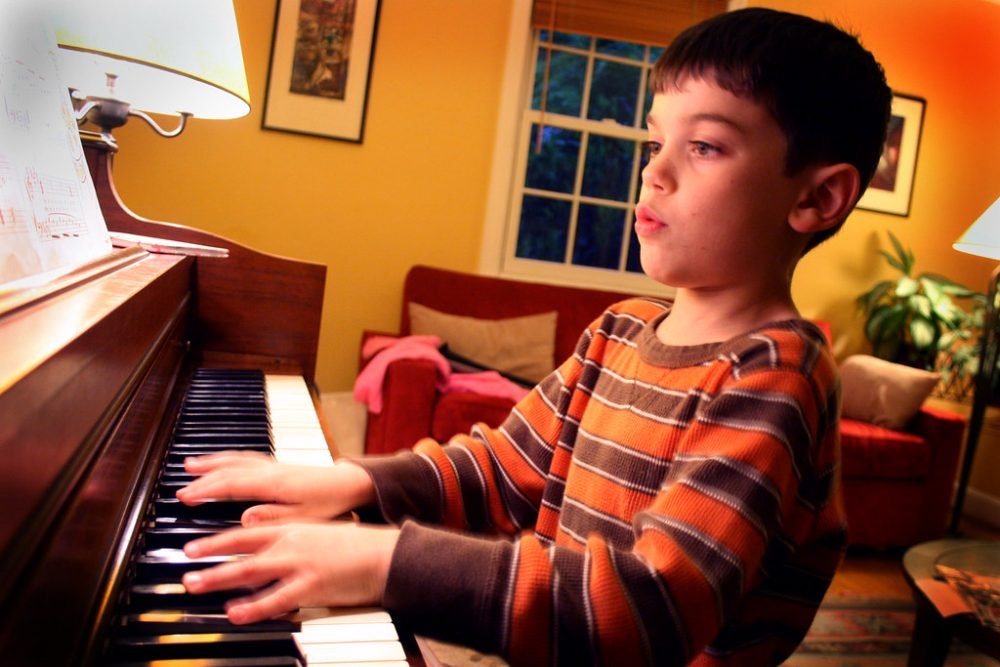kid playing on digital piano