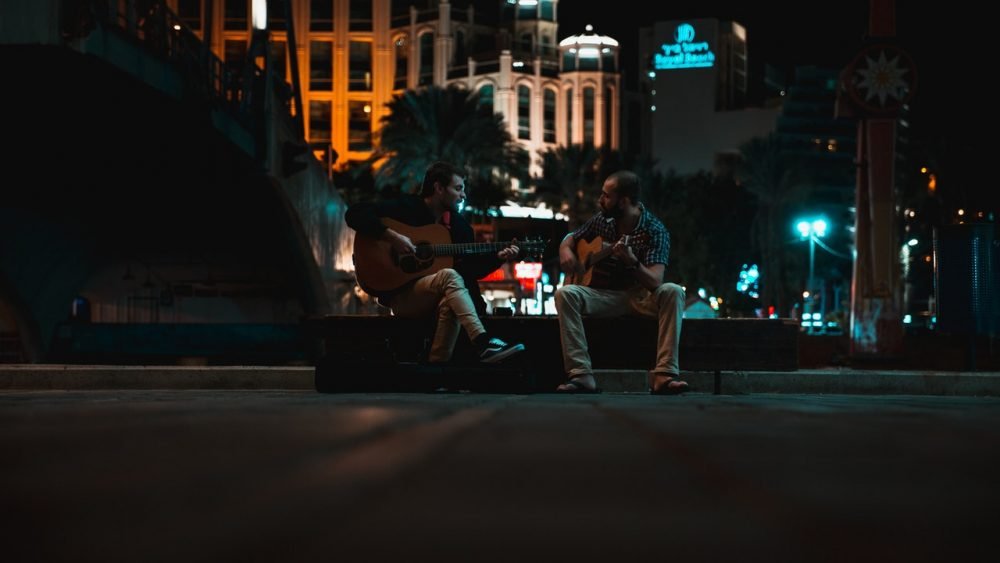 two men playing guitar travel